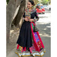 A woman wearing a black and multicolored Gujarati Garba Navratri lehenga chaniya choli with intricate mirror work and embroidery, paired with a black potli bag, standing outdoors with a smile.

