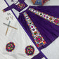A beautifully designed purple and white Navratri lehenga set with intricate Gamthi embroidery, including a blouse, flared skirt, and a dupatta. The set is complemented with silver jewelry, decorated dandiya sticks, and a vibrant embroidered umbrella.