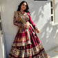 A woman elegantly posing in a maroon Navratri lehenga choli, featuring intricate mirror work, traditional prints, and a beautifully designed dupatta.