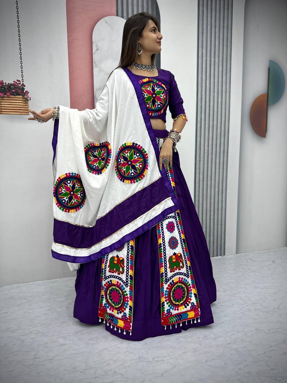  Woman in a purple Gamthi embroidered Navratri lehenga with a white dupatta, featuring traditional motifs and mirror work.







