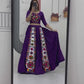 A woman gracefully showcases her traditional Navratri lehenga in front of a mirror, twirling to highlight the intricate Gamthi embroidery and vibrant colors. She admires the detailed patterns on her outfit, adjusting her dupatta and jewelry, radiating confidence and elegance in the festive attire.