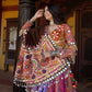 A woman wearing a vibrant Designer Navratri Lehenga Choli adorned with intricate mirror work, embroidery, and tassels, perfect for Garba and Dandiya nights.
